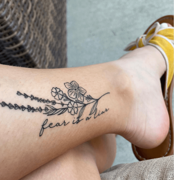 A cute floral and "Fear is a liar" tattoo on the leg.