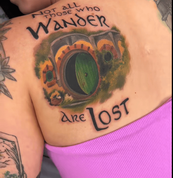 A realistic "Not all those who wander are lost." tattoo with deep meaning on the back -shoulder.