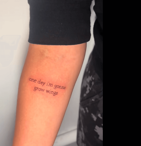 A "One day I’m gonna grow wings." tattoo on the hand.