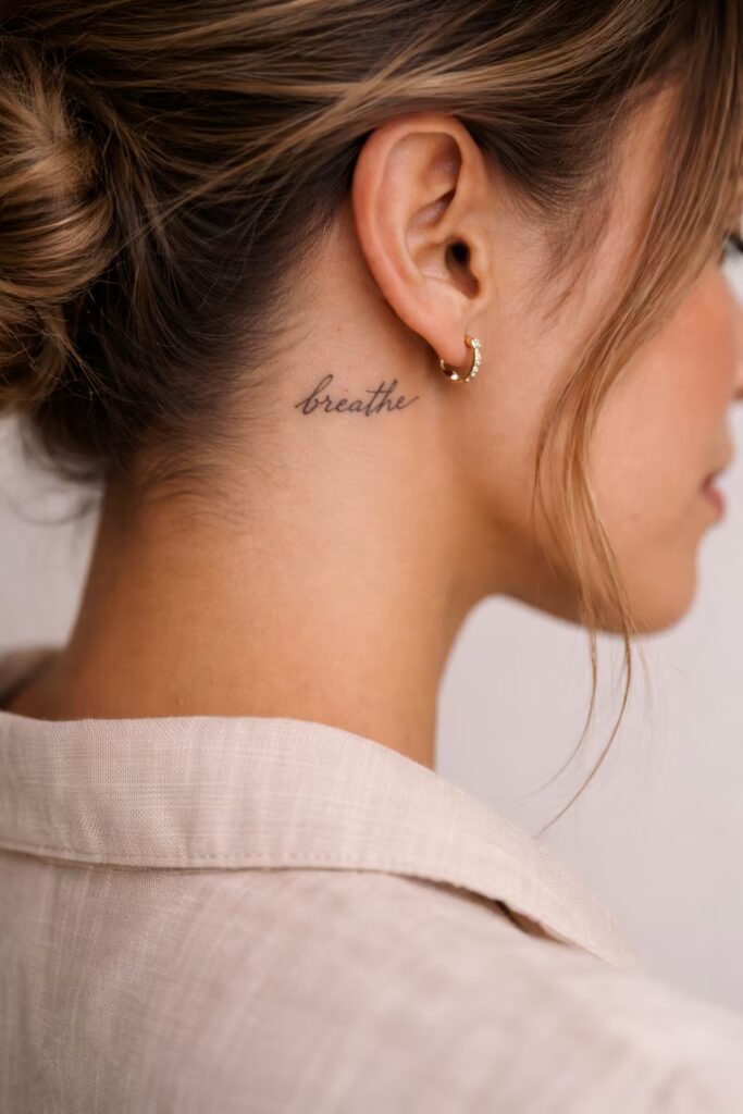 Tiny Script Quote “Breathe” Behind the Ear Tattoos